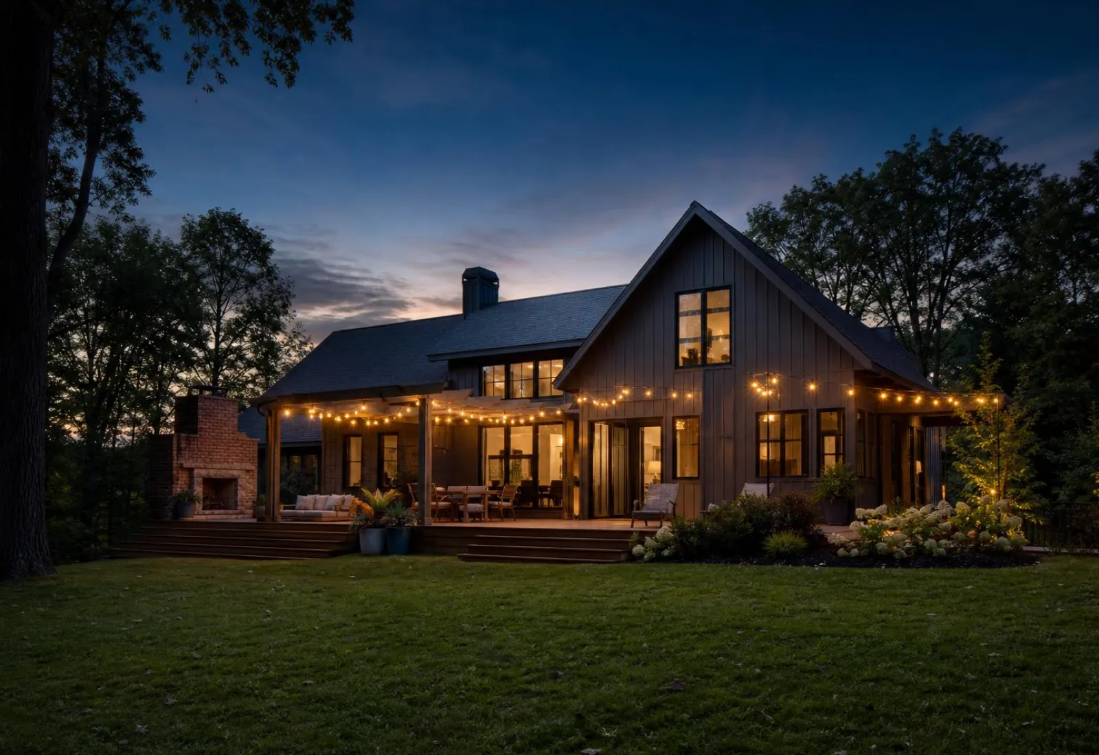 Warmly lit modern home exterior with a new deck at twilight